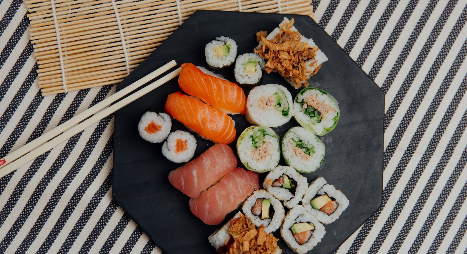 plate with sushi rolls near chopsticks
