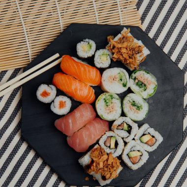 plate with sushi rolls near chopsticks