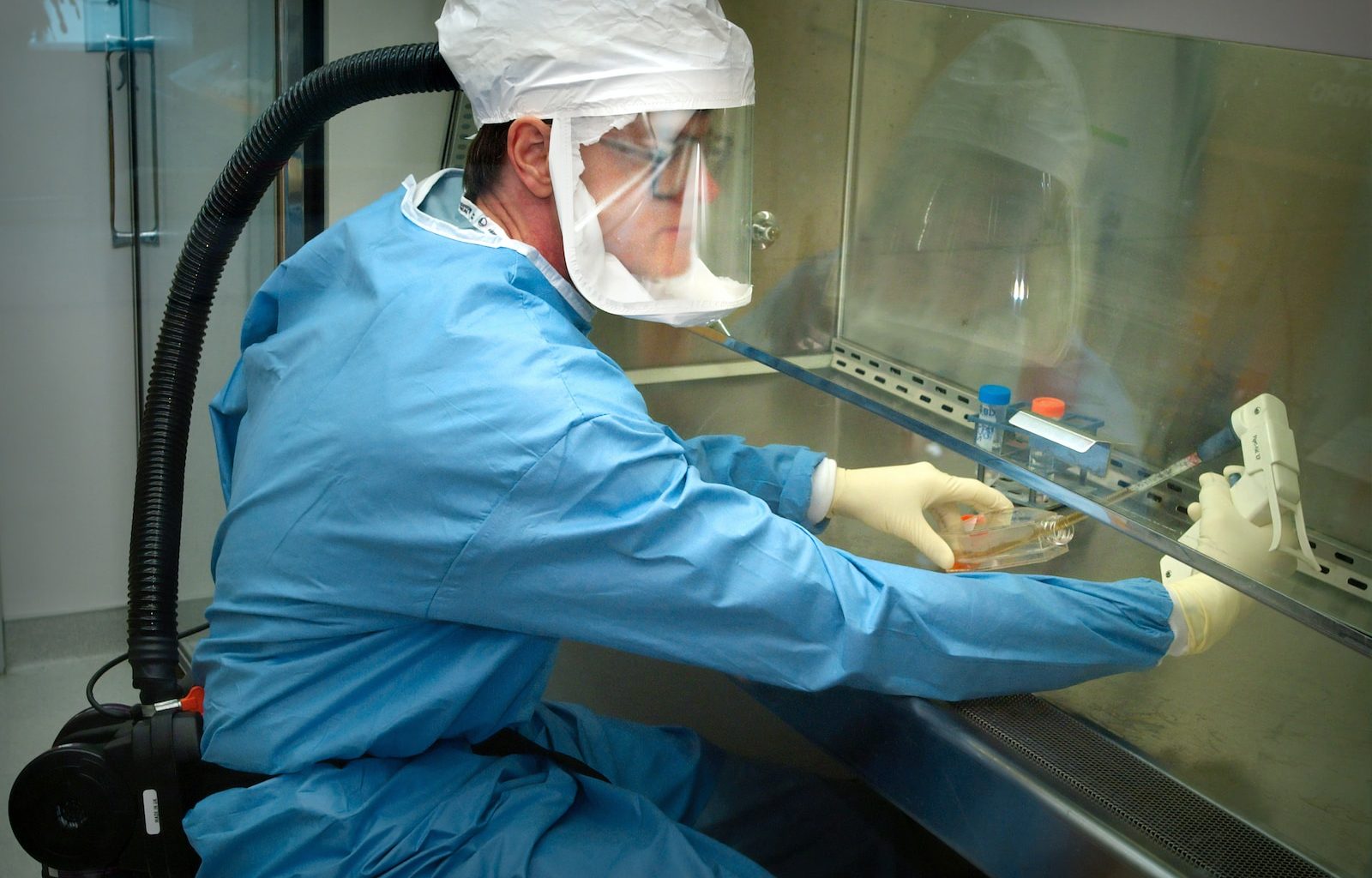 a man in a protective suit and mask working on a machine