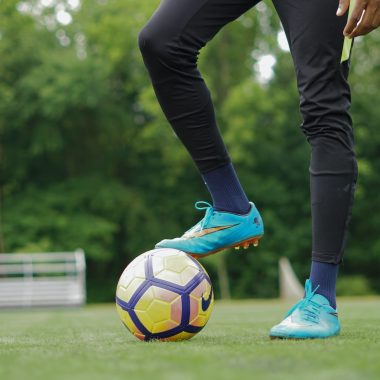 person in blue nike soccer shoes and black pants