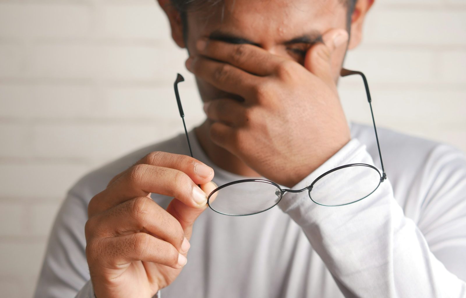 a man holding a pair of glasses up to his face