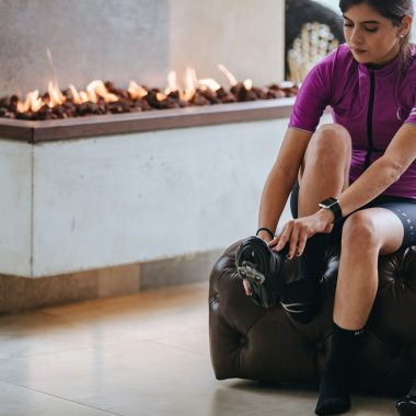 woman in purple crew neck t-shirt and black shorts sitting on white floor