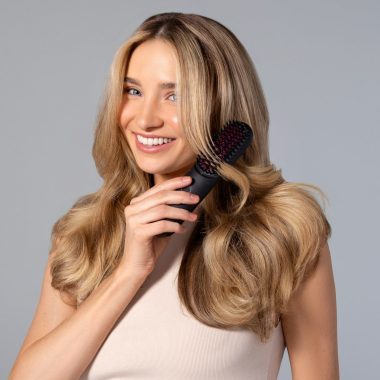 a woman holding a hair brush in her hand