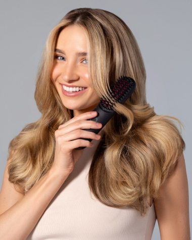 a woman holding a hair brush in her hand