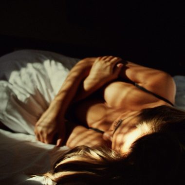 a woman laying on top of a bed next to a man