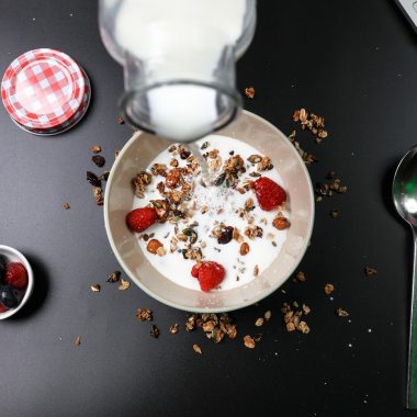 Bakje Griekse yoghurt met komkommer en verse kruiden op een zomerse tafel