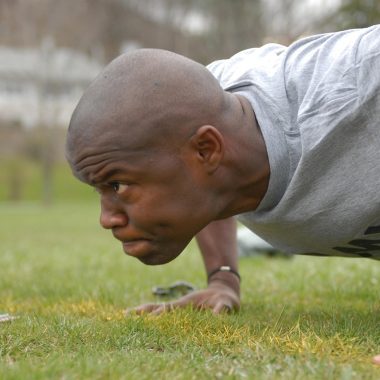 Man doet push-ups op de vloer als onderdeel van krachttraining oefeningen zonder gewichten