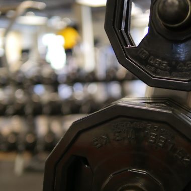 Persoon die een dumbbell optilt in de sportschool tijdens krachttraining