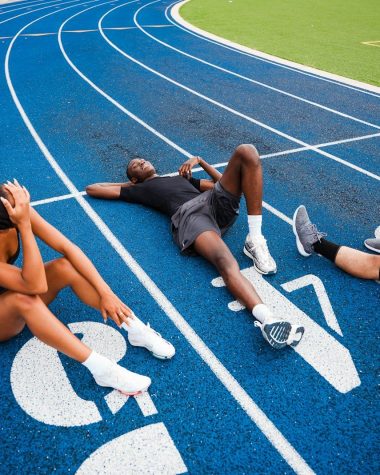 Athletes resting on a blue running track