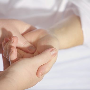 Iemand gebruikt een massage gun op de bovenbeen spieren na het sporten
