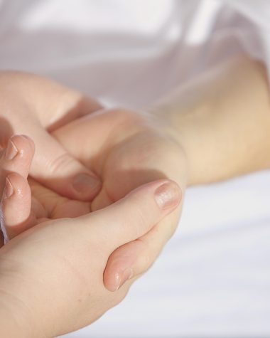 Iemand gebruikt een massage gun op de bovenbeen spieren na het sporten