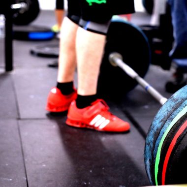 Persoon die een barbell optilt in de sportschool tijdens een krachttrainingssessie