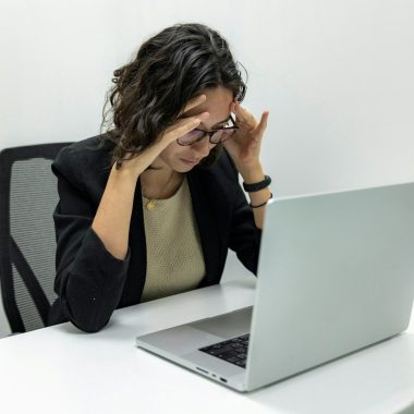 a woman sitting in front of a laptop computer