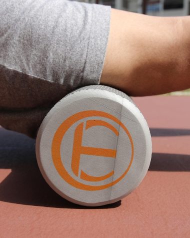 Persoon die een foam roller gebruikt op de vloer om zijn rug los te maken na het sporten