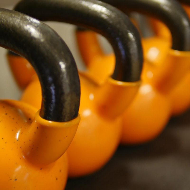 Een tiener traint met gewichten in een gymzaal op school