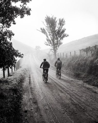 Mountainbiker rijdt door modderige herfsttrail in het bos