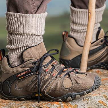 Natte hardloopschoenen die drogen met krantenpapier erin op een houten vloer