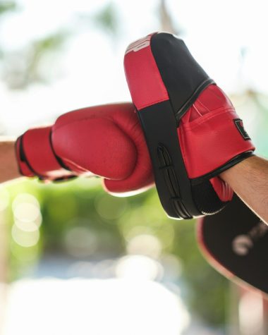 a person wearing a red and black boxing glove