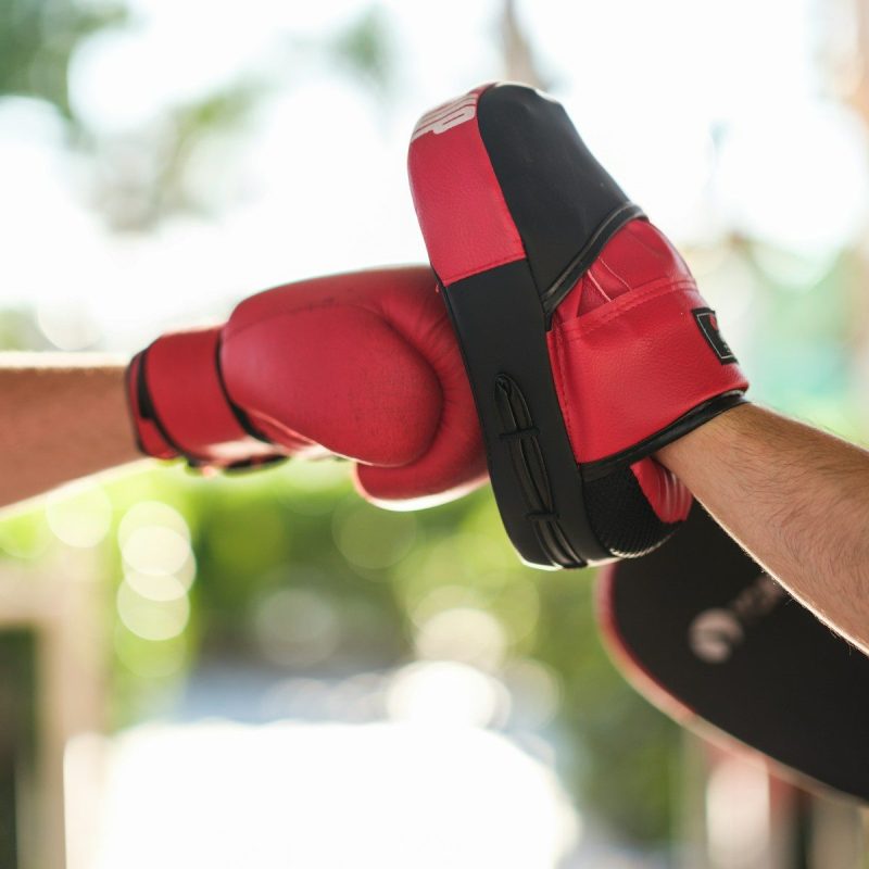 a person wearing a red and black boxing glove