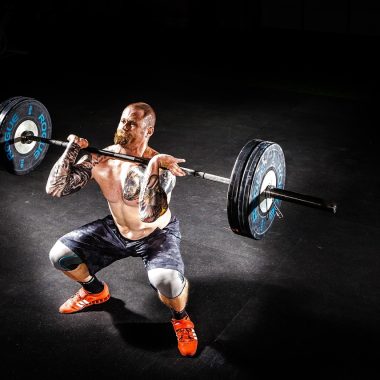 Persoon die bankdrukt in de sportschool met aandacht voor schouder en elleboogpositie